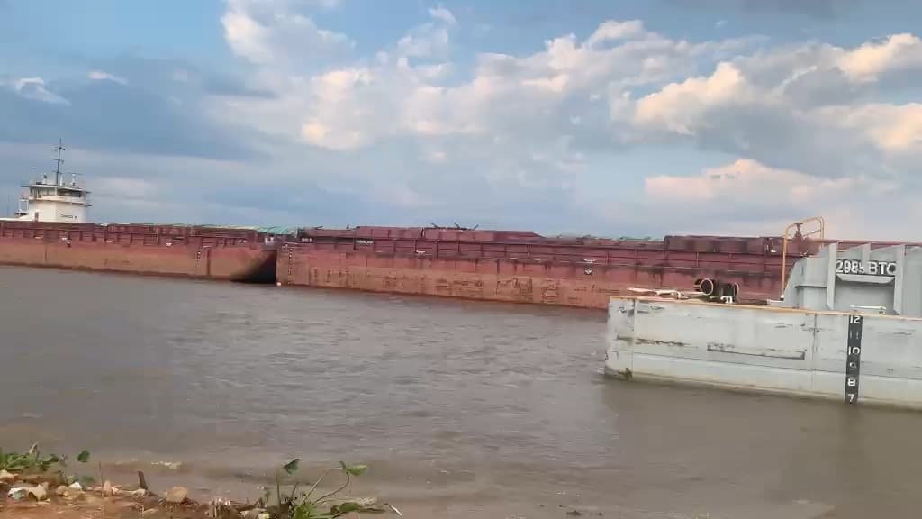 Barcazas amarradas sobre el río vistas desde la costa